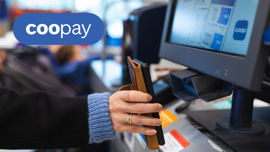 En som scanner mobilen ved kassa.