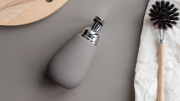 Beige såpedispenser og oppvaskbørste i tre