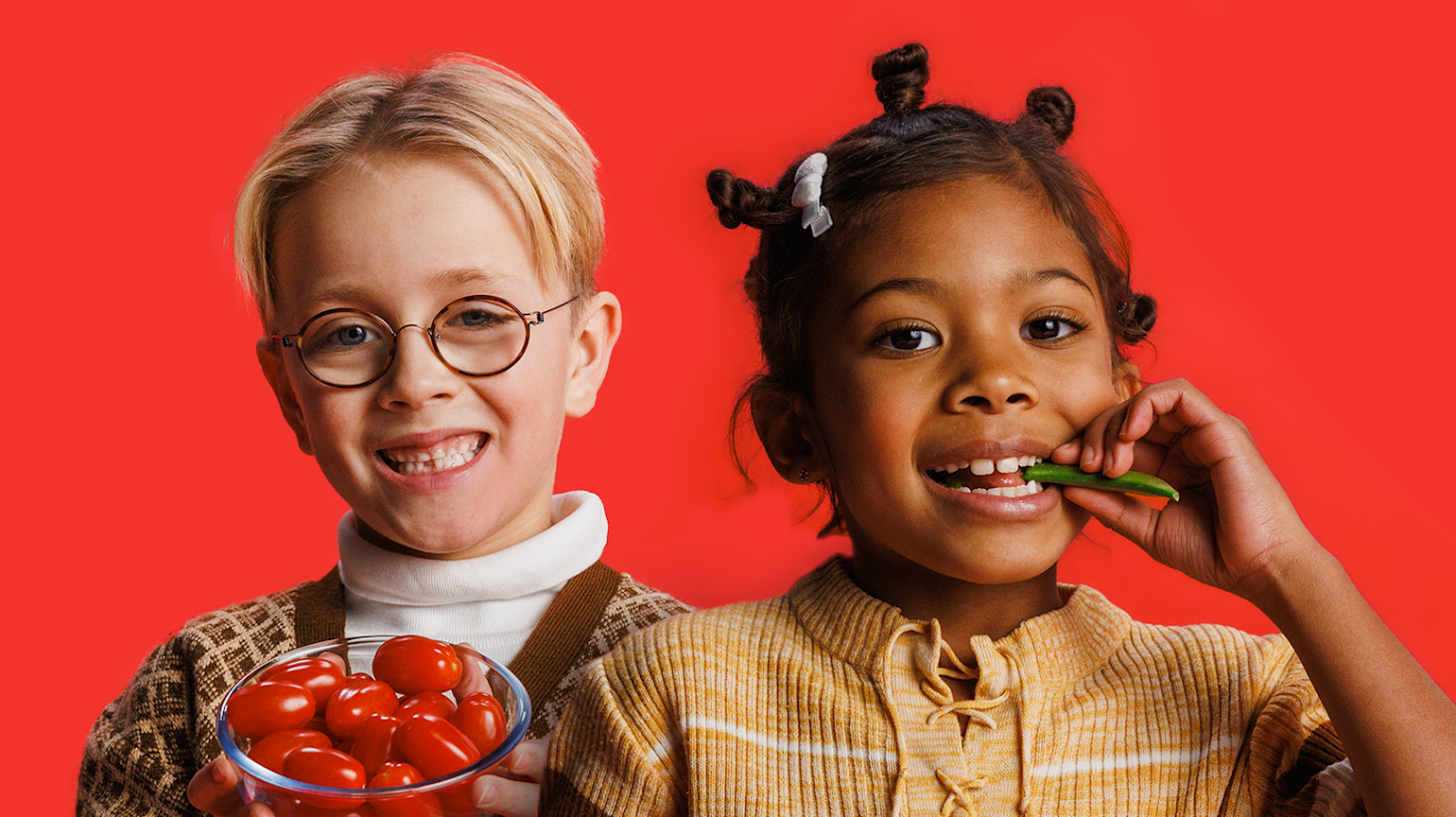 En gutt og en jente som spiser grønnsaker