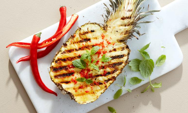 Spicy grillet ananas. Halv ananas med finhakket chili, og mynte på toppen.