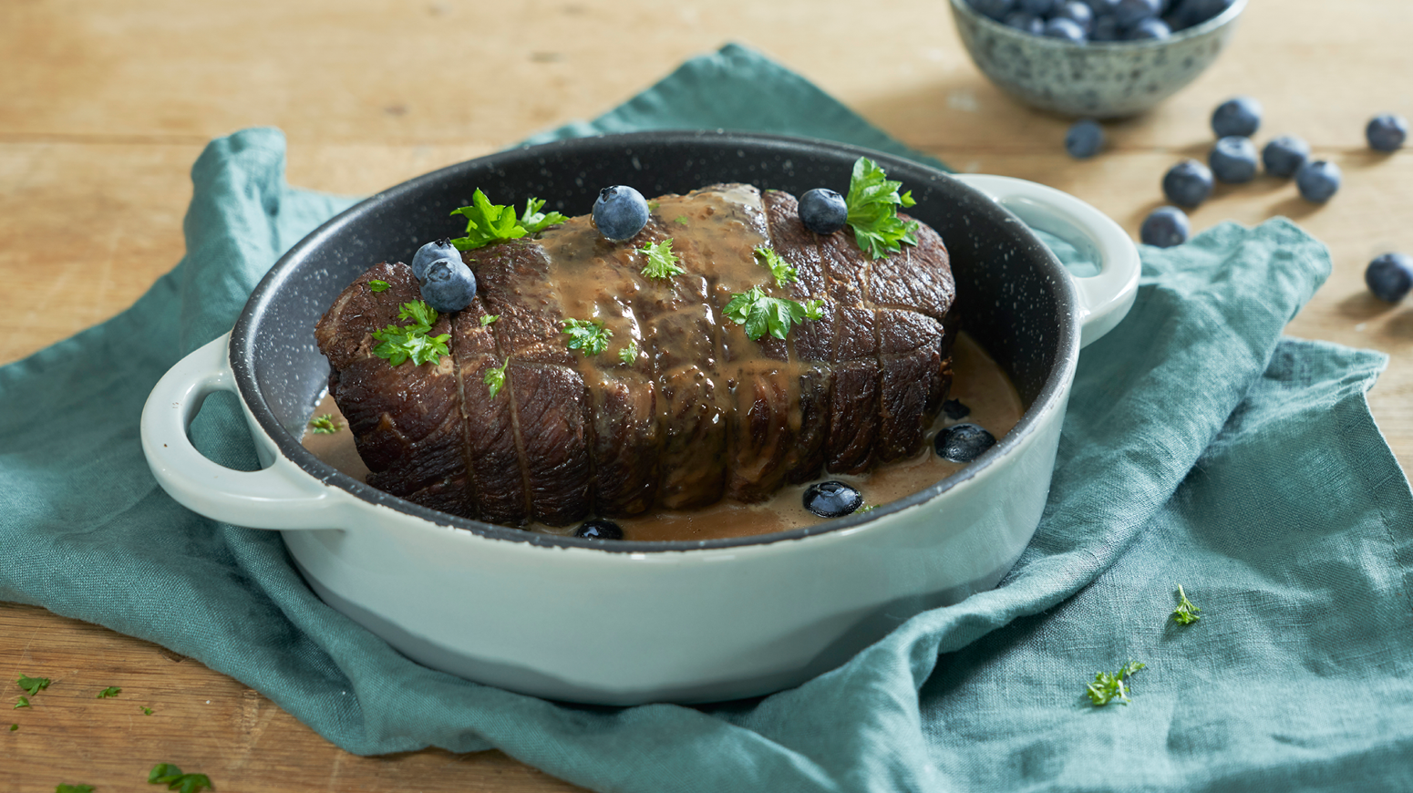 Oksestek i gryte med blåbær på toppen.