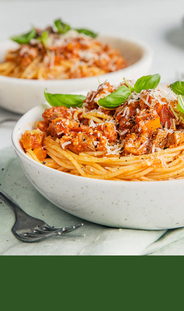 Pastarett i i hvit skål med basilikum på toppen