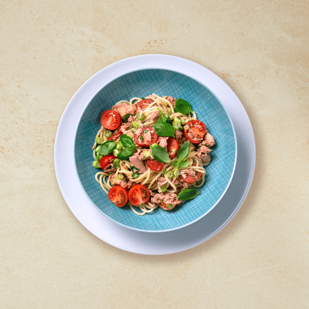 Spagetti med tunfisk og cherrytomater, basilikum og vårløk. Servert i turkis pastaskål.