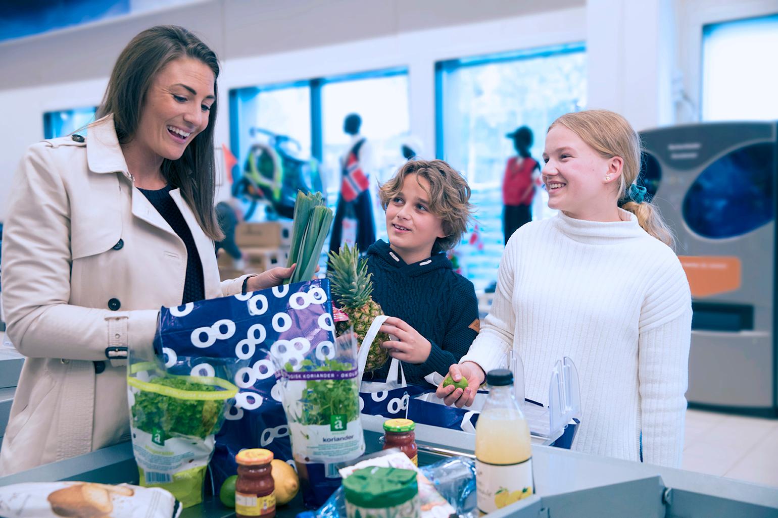 Familie pakker varer i butikk