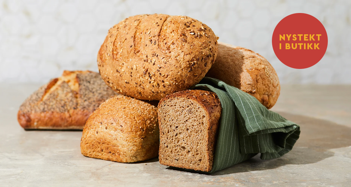 Et utvalg butikkstekte brød fra Coop Mega, dandert oppå hverandre med et mørkegrønt linhåndkle mellom.