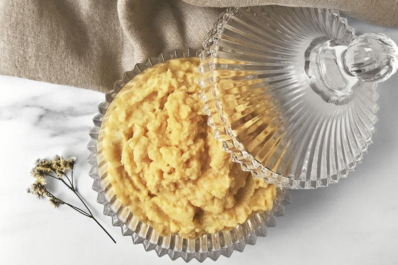 Hjemmelaget kålrotstappe i gjennomsiktig krystallbolle med tilhørende lokk. Bollen står på hvit marmorbakgrunn, med beige linduk.