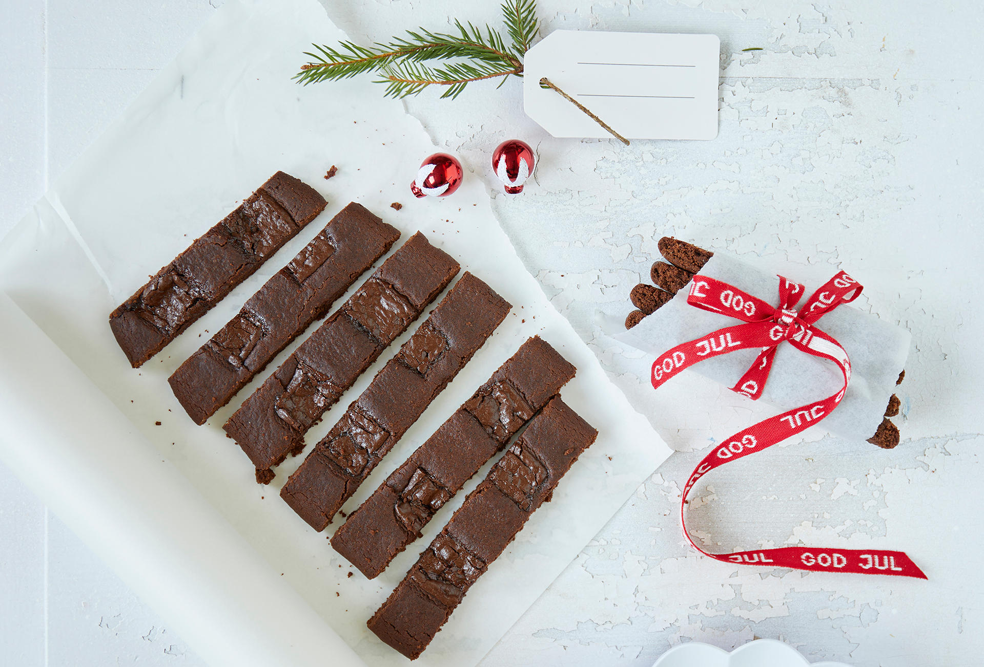 After Eight-snitter servert på hvitt bakepapir, med en stabel snitter pakket inn i bakepapir og knytt sammen med rødt julebånd ved siden av.