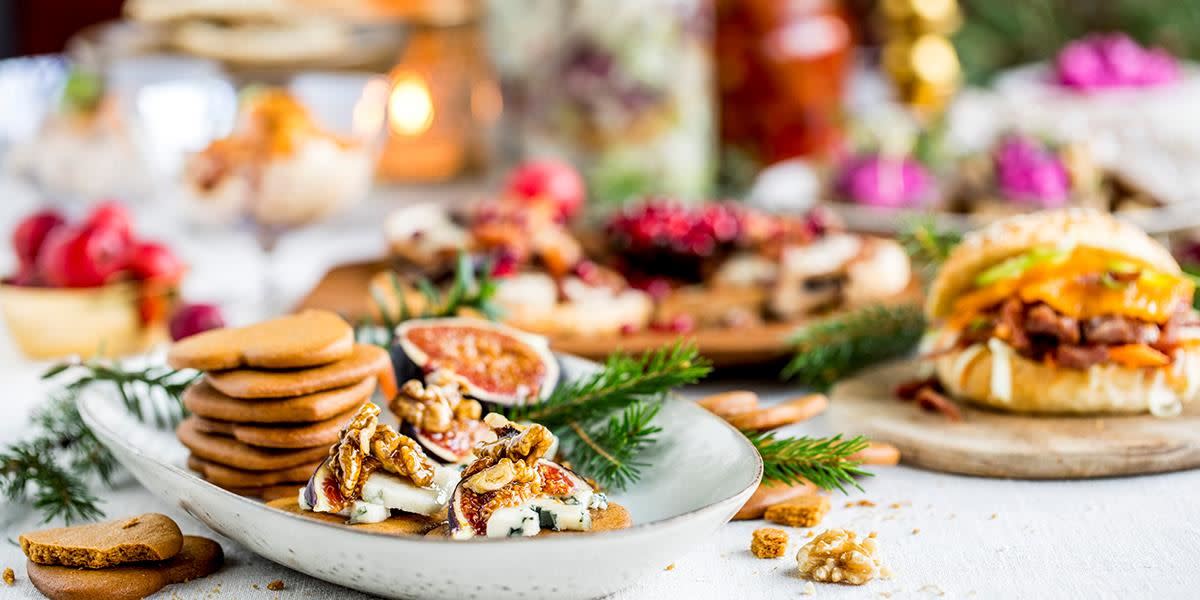 Julebord pepperkaker granbar fiken og julepynt på fat