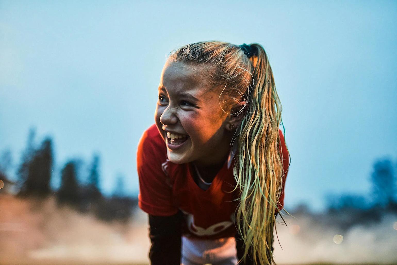 Jente i Coop fotballdrak tar seg en hvil