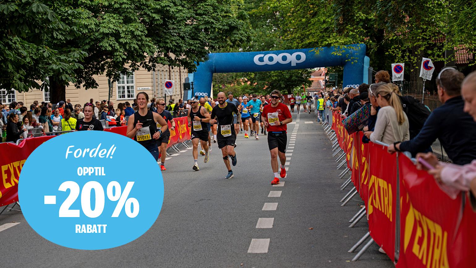 Mange mennesker løper fra startstreken på Trondheim Maraton. Grønne trær i bakgrunn