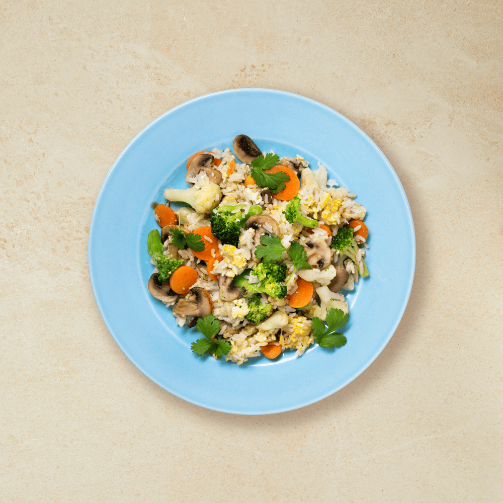 Stekt ris med grønnsaker servert på en blå tallerken 