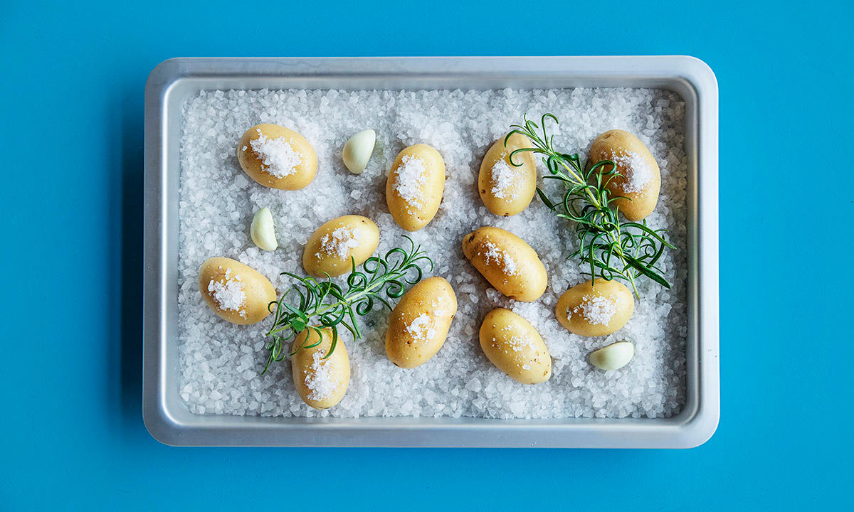 Saltbakte poteter på grovt havsalt i ildfast form sammen med rosmarinkvaster.