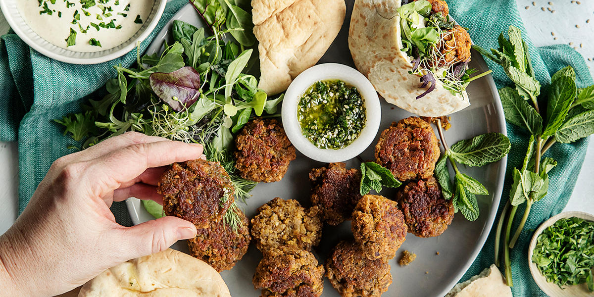 Fantastisk falafel, laget med røde linser og servert med pitabrød, dressing og urtesaus.