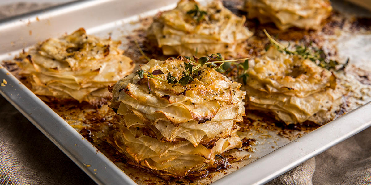 Stekebrett med gratinerte stabler av sellerirot med ost og frisk timian.