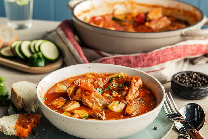 Tomatisert lammegryte med squash og bønner, servert i lys skål. Rødstripete linduk ved siden av.