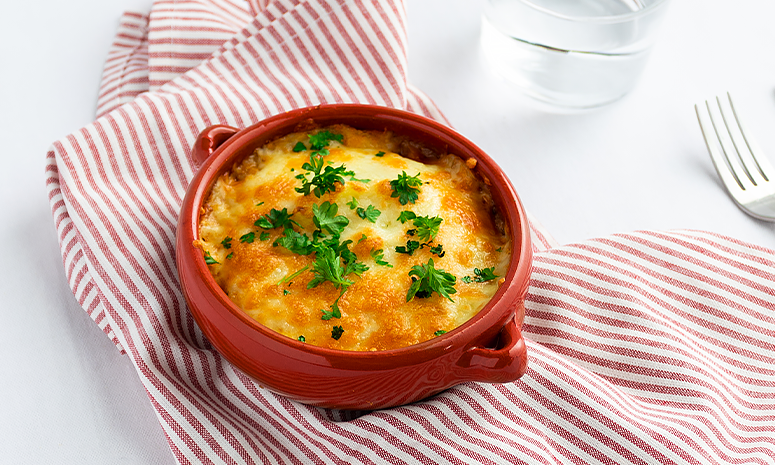 Gratinert kjøttdeig med potetmos og revet ost i en form