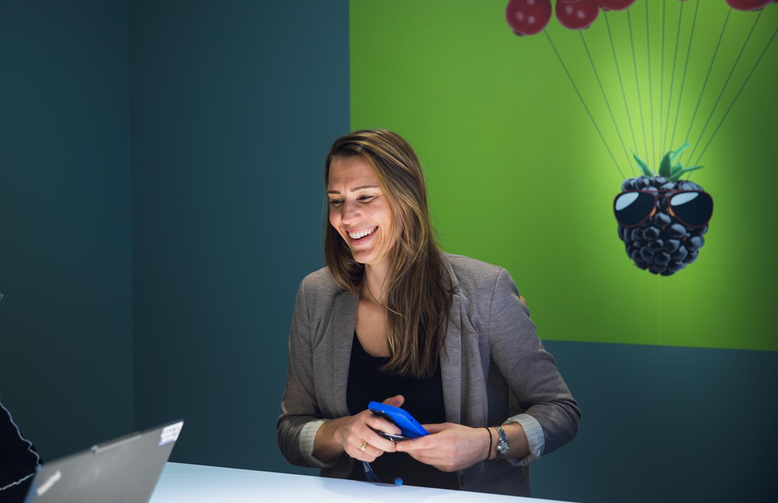 dame smiler med tlf i hånden