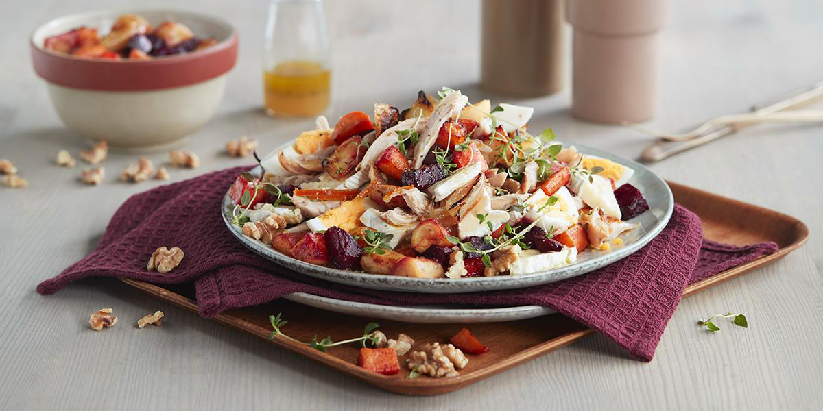 Tallerken som bugner med høstsalat med stekte rotgrønnsaker og kylling i biter.