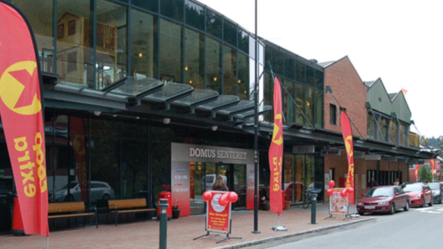 Bilde av Domus Støren tatt fra bakkeplan. Røde og gule Coop Extra vimpler utenfor butikken.