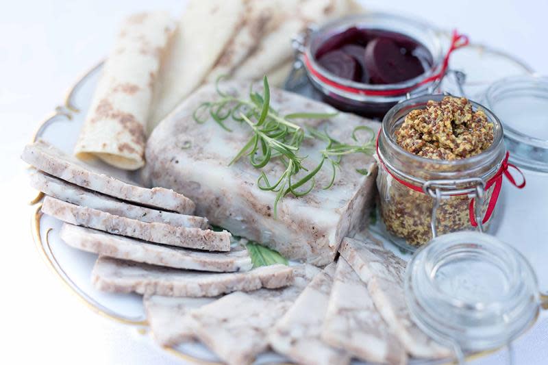 Hjemmelaget sylte servert på lyst fat, med lefser, grov sennep og rødbeter på siden.