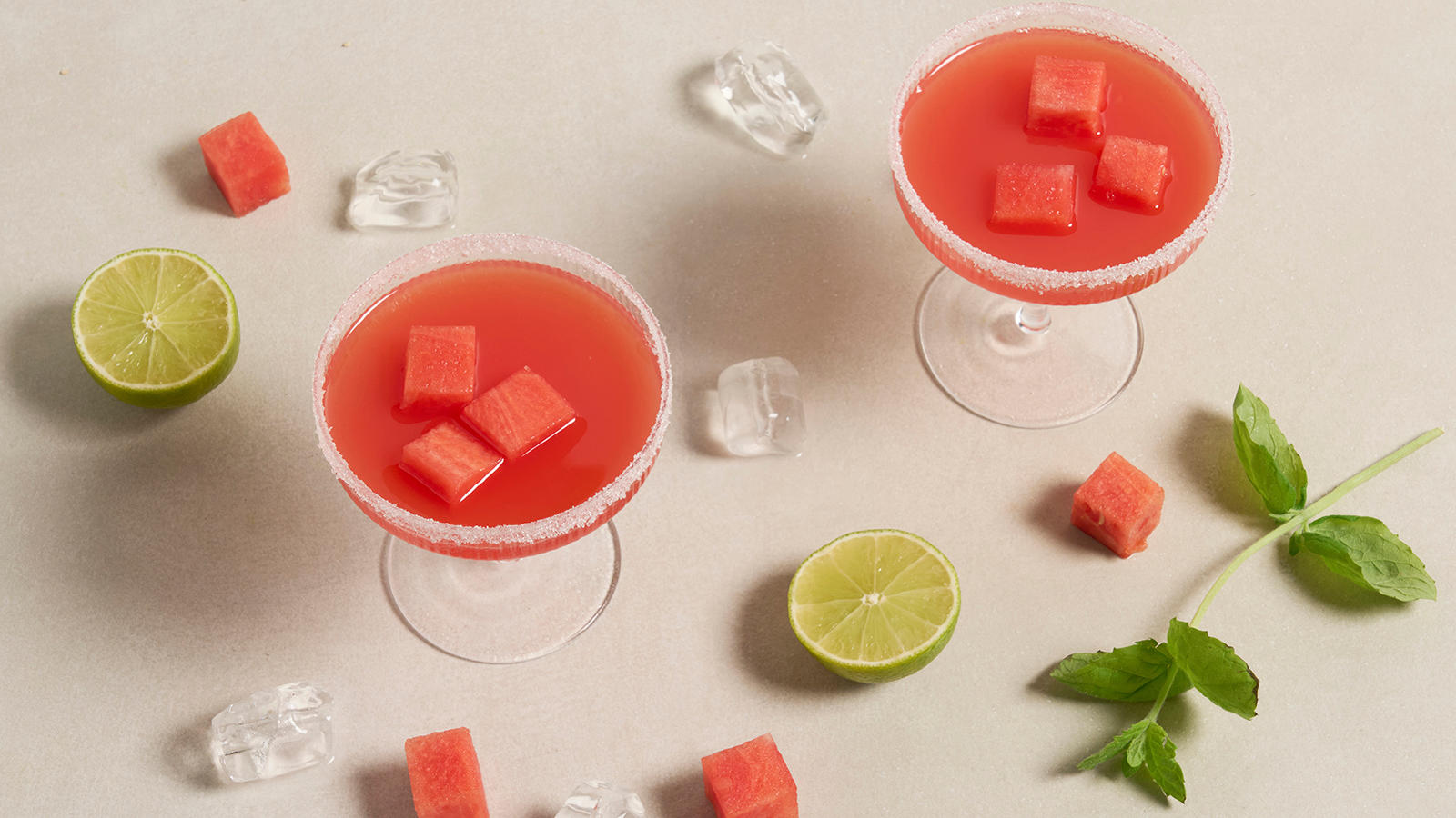 Vannmelon margarita - mocktail servert i cavaskåler med sukker på kanten, omringet av vannmelonbiter, frisk mynte, lime og isbiter.
