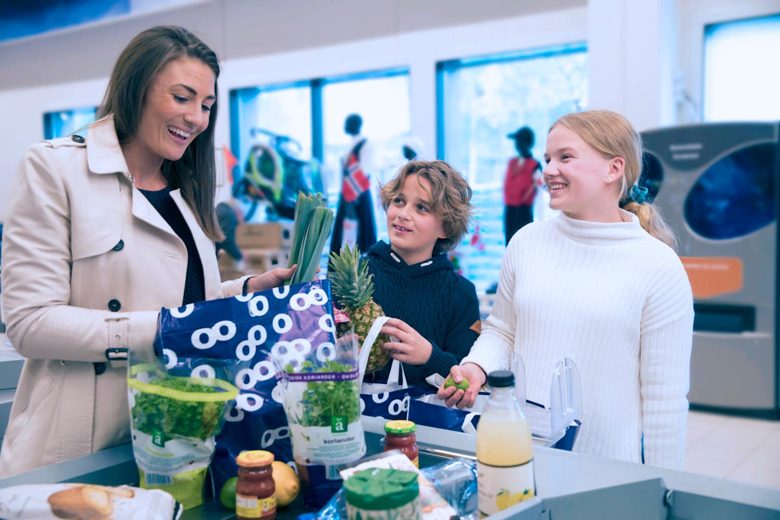 Familie pakker varer i butikk