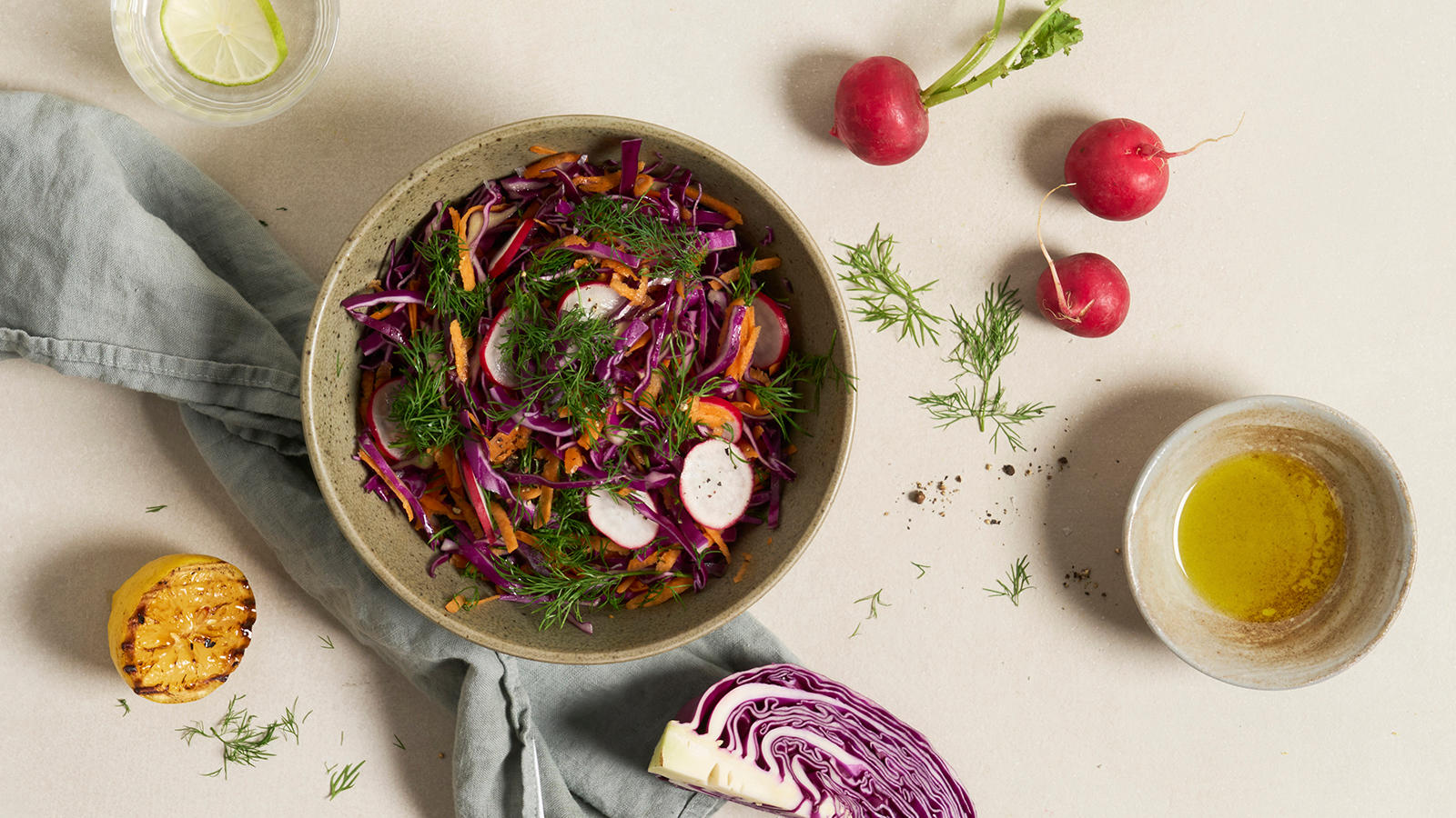 Frisk sommersalat med rød spisskål, gulrot og reddik servert med frisk dill i keramikkbolle.