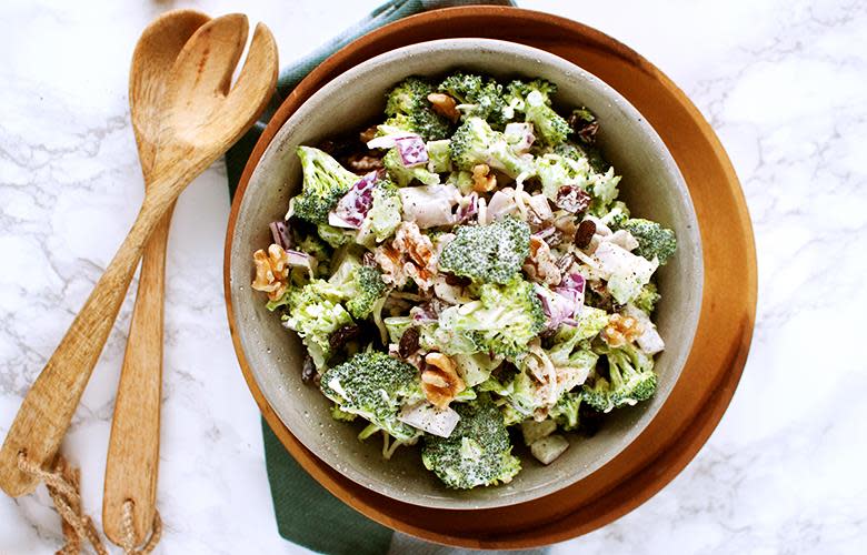 Hjemmelaget kremet brokkolisalat, servert i lys bolle, på mørkt trefat. Marmorbakgrunn.