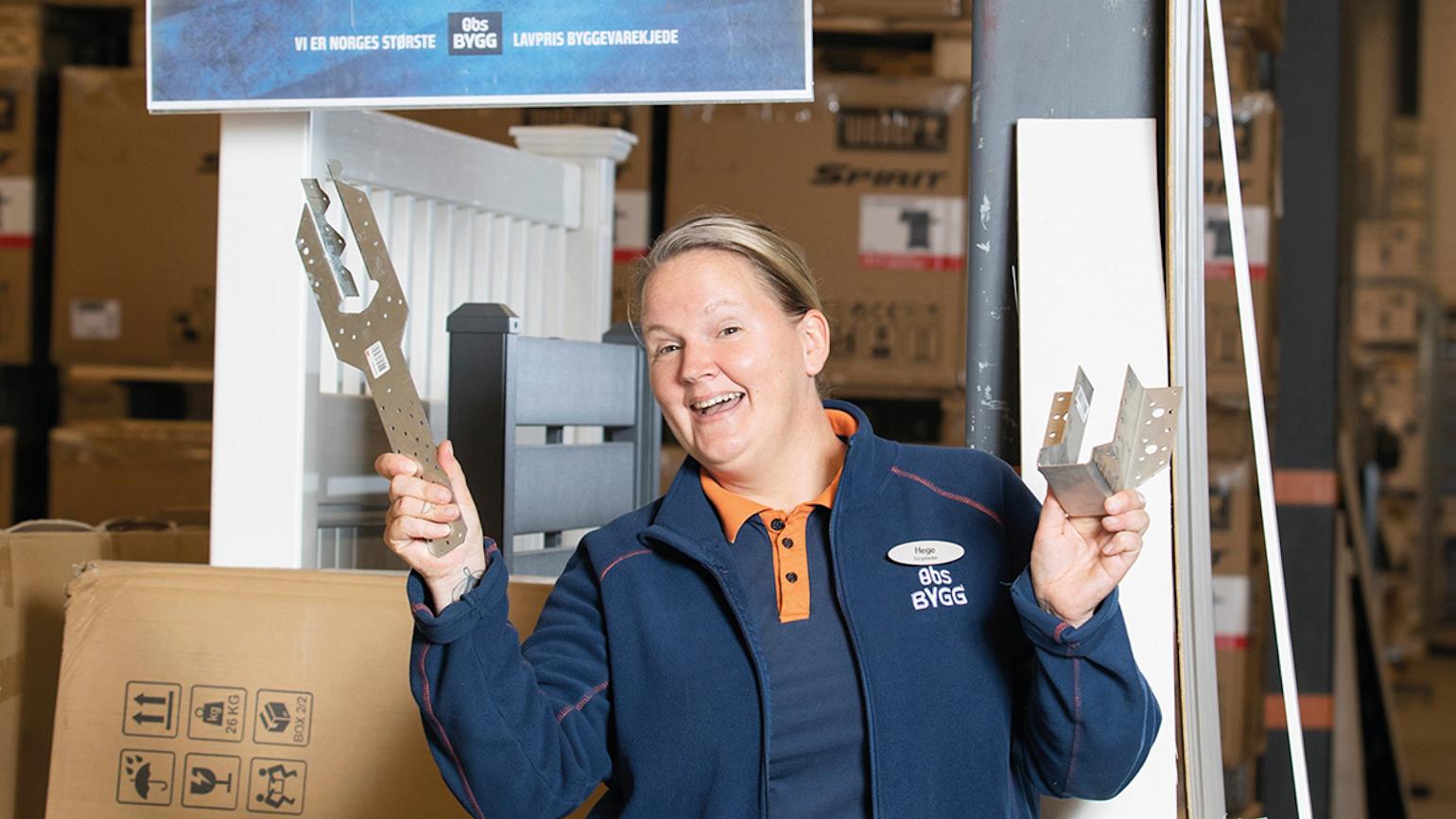 Dame smiler i Obs Bygg klær på lager.