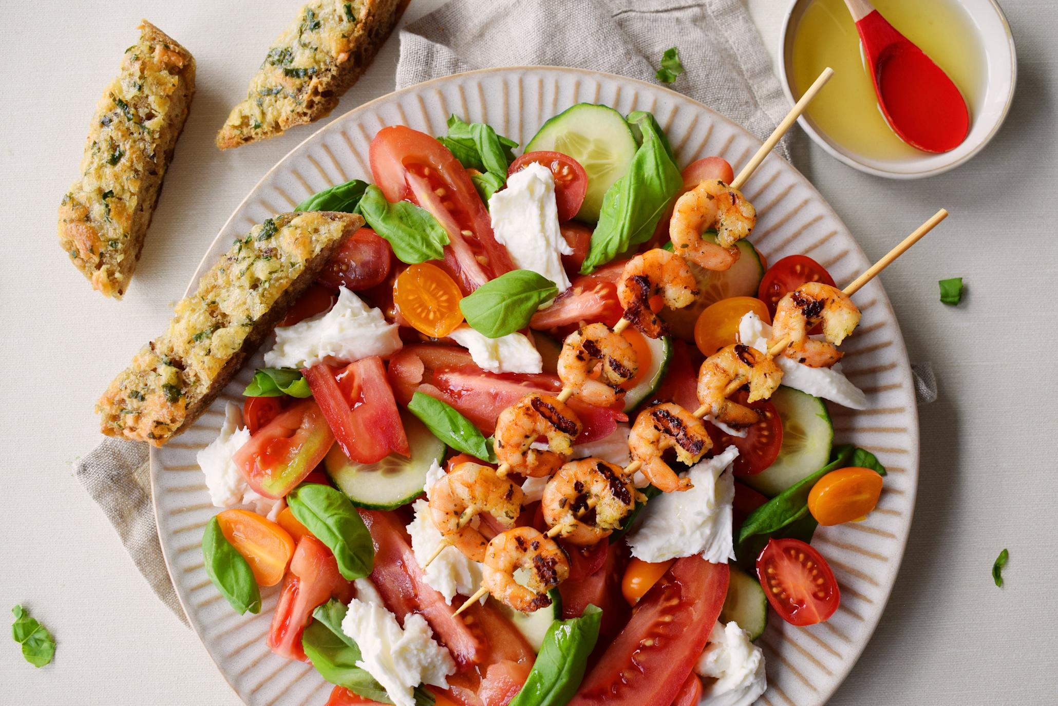 Italiensk sommersalat med grillet scampi, fersk mozzarella, tomater i flere farger, basilikum og hjemmelagede hvitløksbrød.