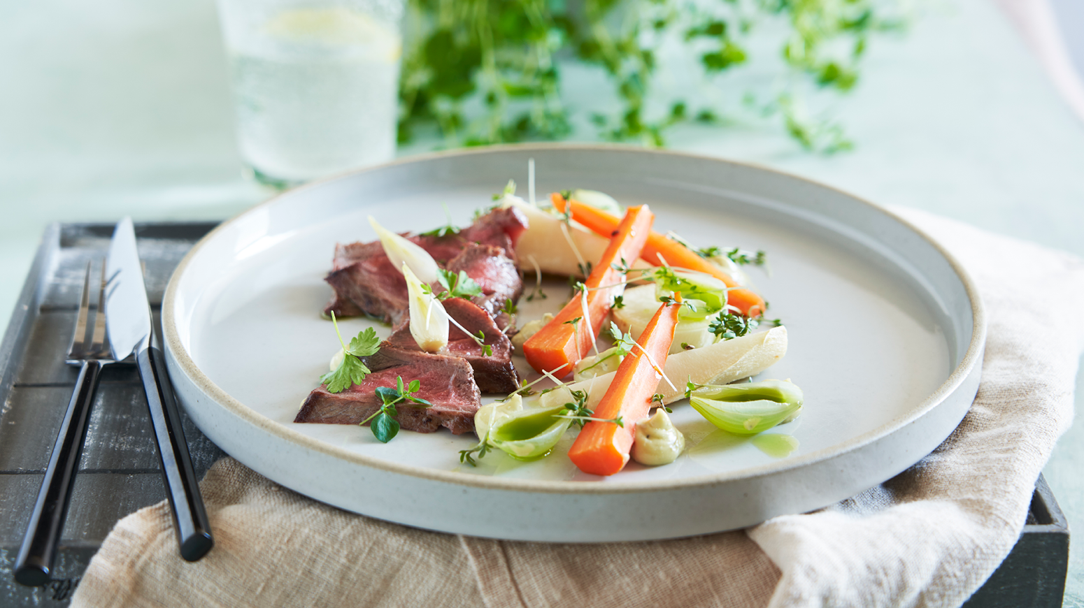 Biff på en tellerken med grønnsaker rundt.