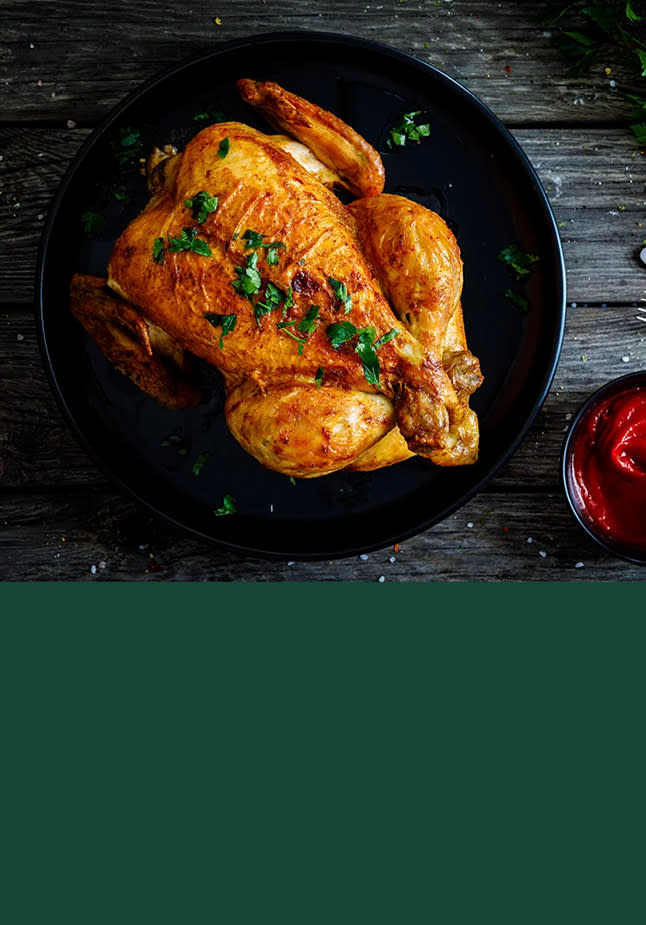 Helstekt kylling på sort fat øverst og grønn bakgrunn nederst