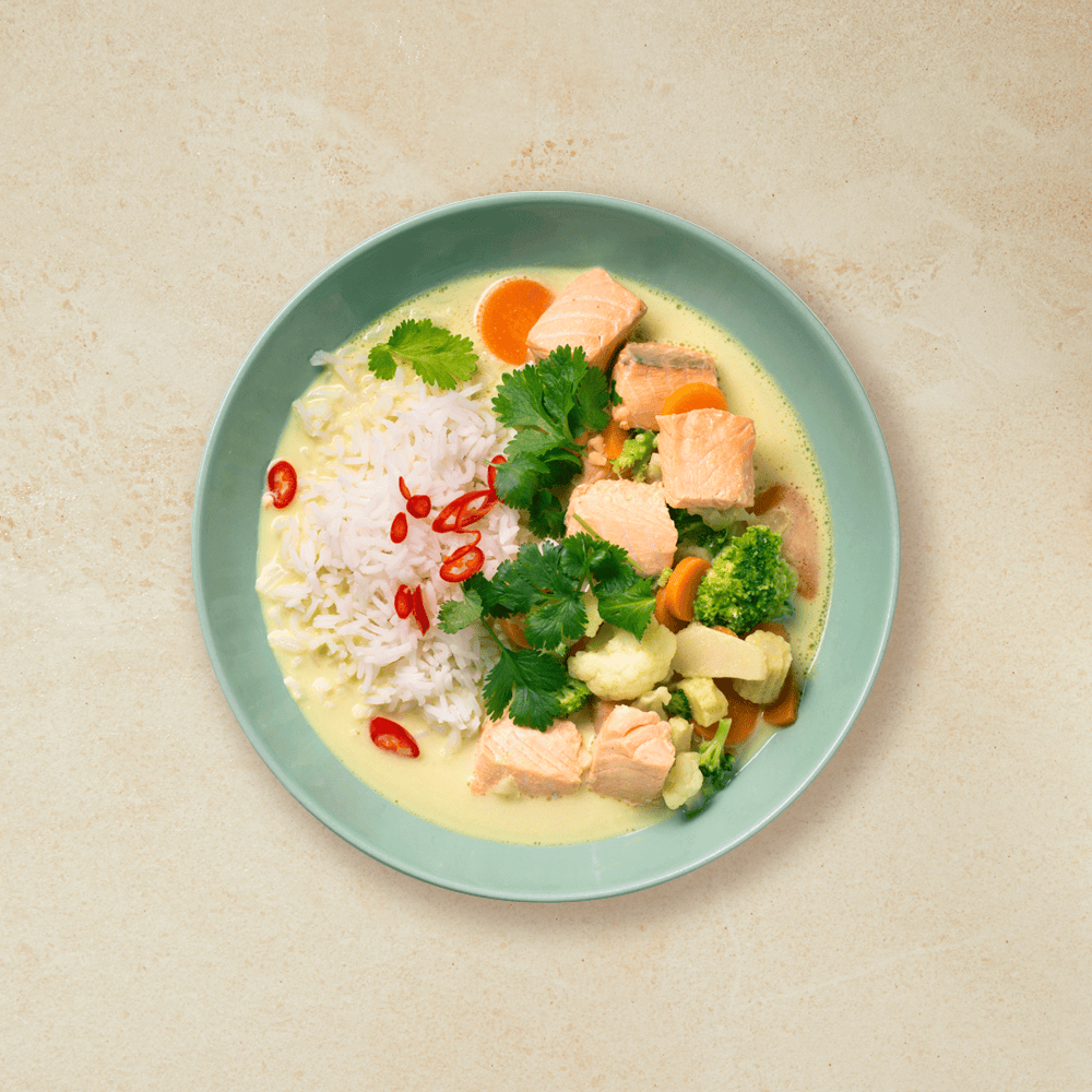 Laks i karri med kokosmelk, ris og grønnsaker, i en grønn skål