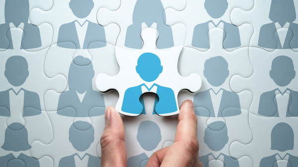 Bilde av en hånd som holder en puslespillbrikke med hoder på.