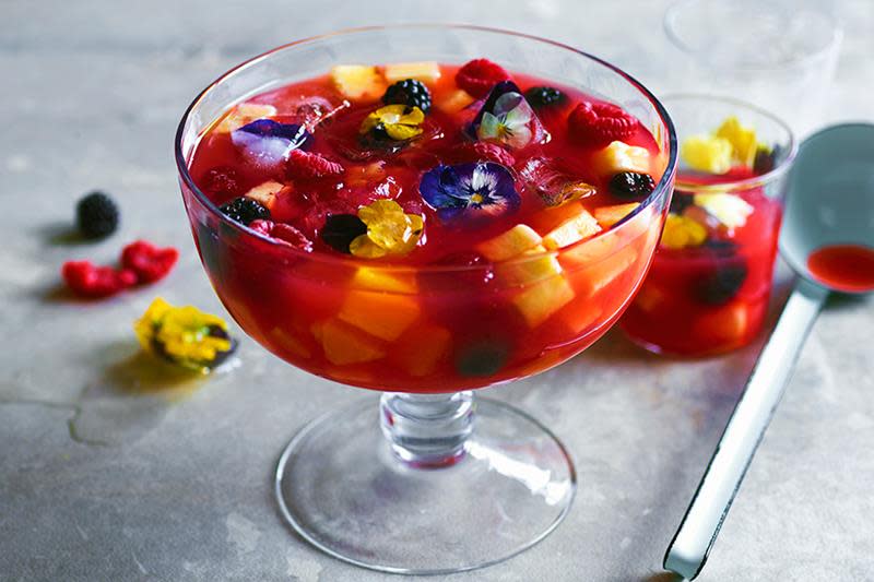 Punsjskål med rød punsj, frukt og blomsterpynt