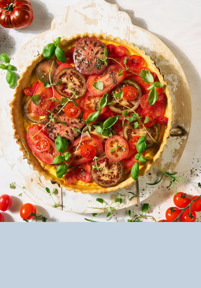 Tomatpai på hvit tallerken med små tomater rundt