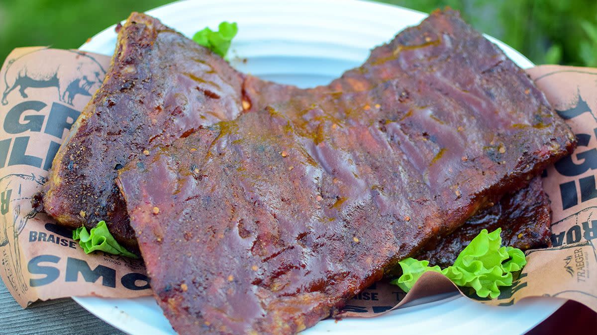 Spareribs med 3-2-1-metoden, servert på tallerken med bakepapir, salat og bbq saus.