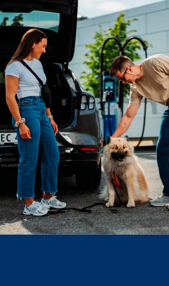 Lyseblå bakgrunn nederst og bilde av et par og hund foran bil som lader over
