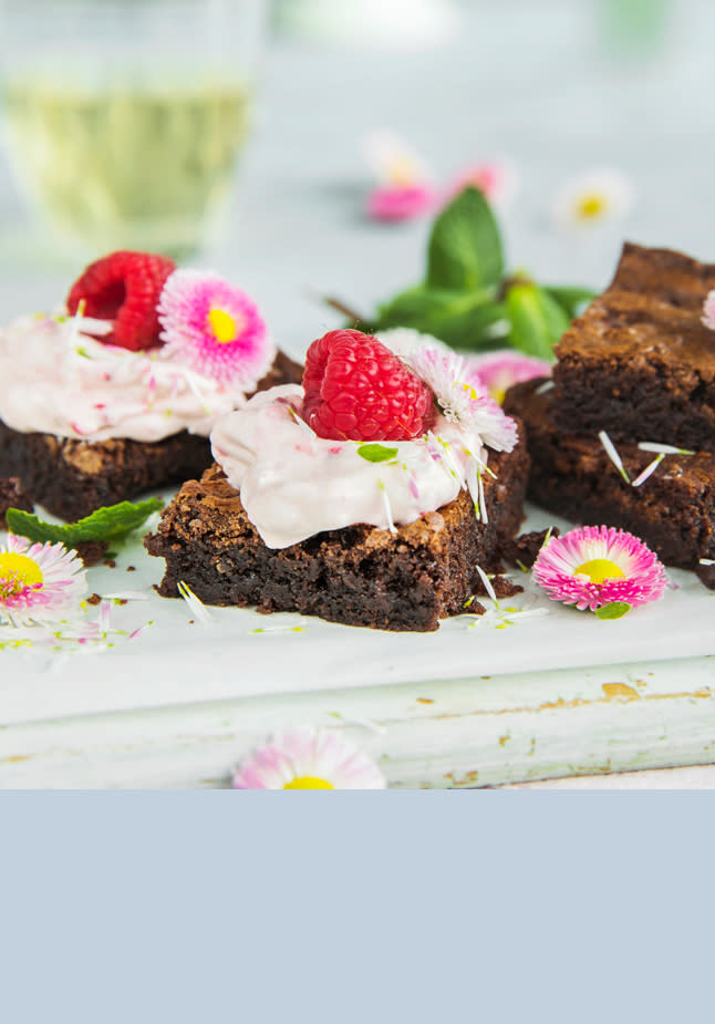 Svensk kladdkaka med bringebærkrem og blomster som pynt