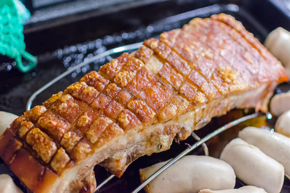 Ribbe med stekt svor med biter av julepølse rundt