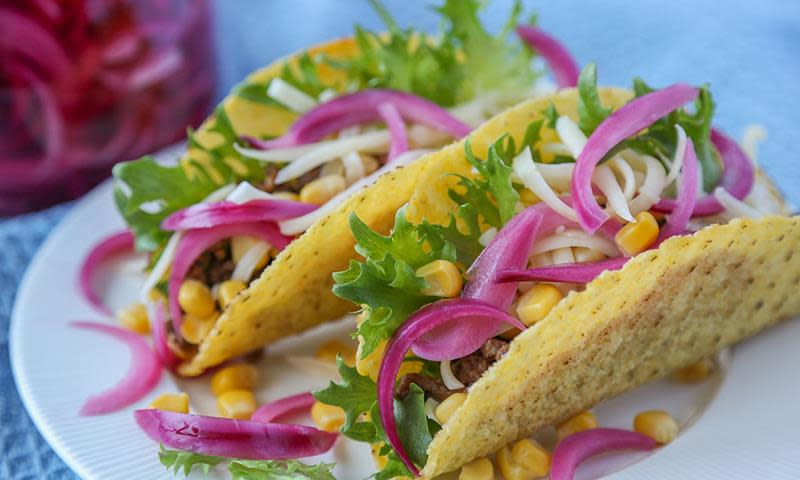 Tacoskjell med kjøttdeig, salat, mais og ost. Toppet med juksesyltet rødløk.