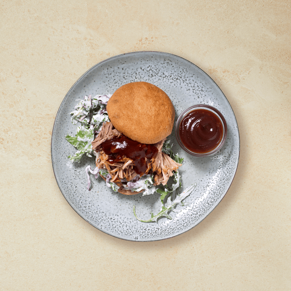 Pulled pork burger med coleslaw på en grå tallerken