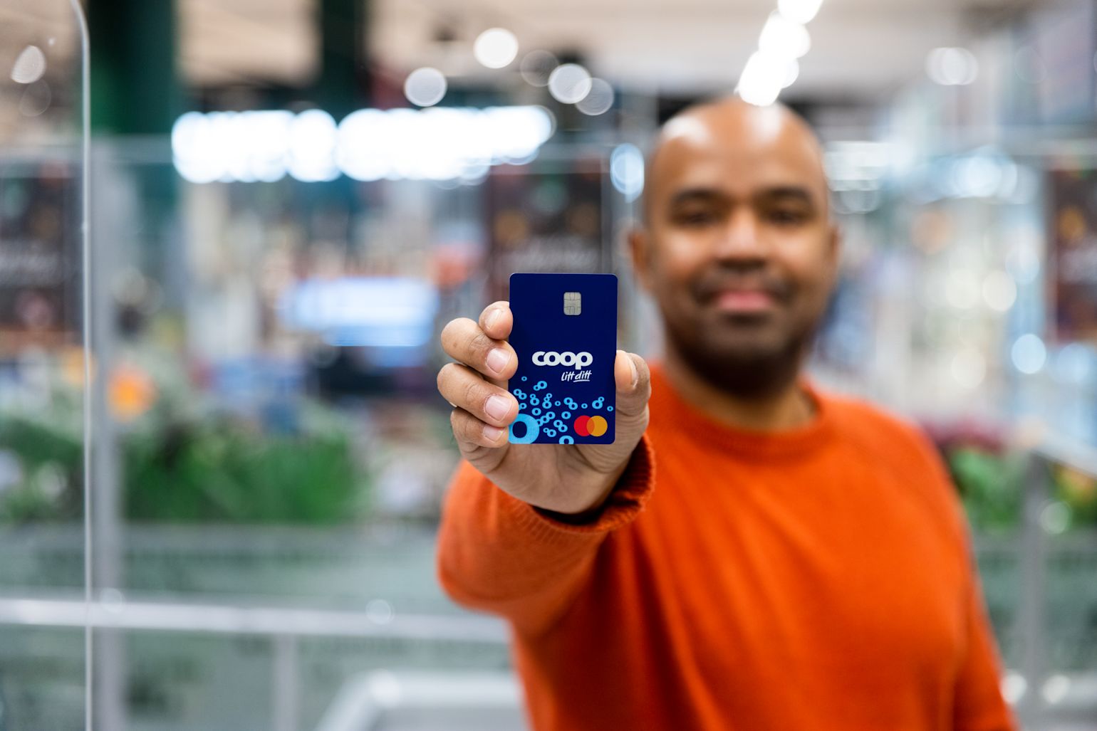 Mann holder opp et Coop Mastercard fra Sparebank1