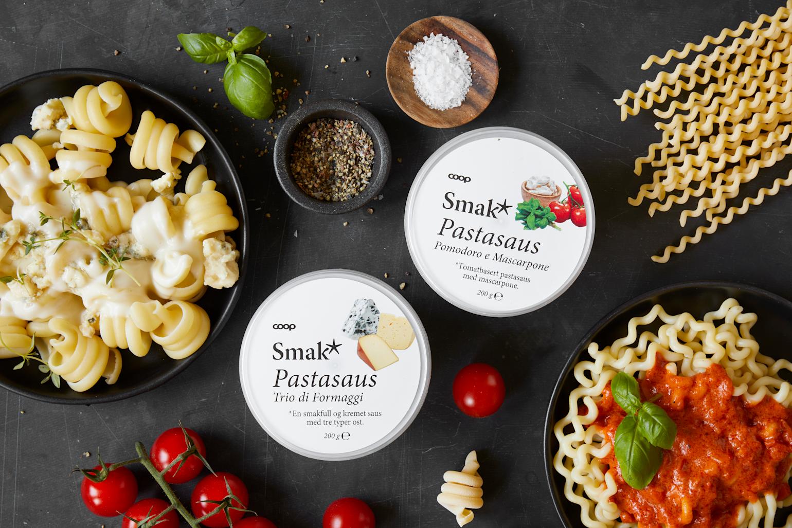 Smak pastasaus med pasta, basilikum og tomater på svart på bakgrunn