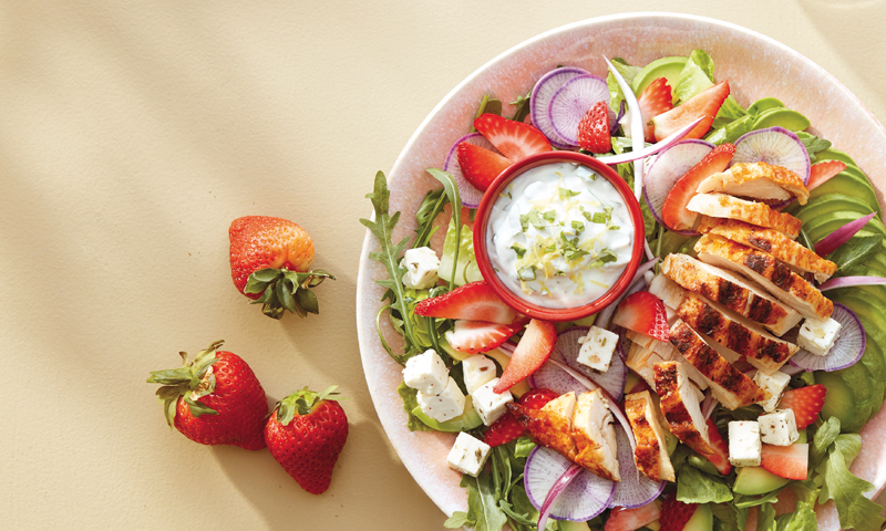 Kyllingsalat med urtedressing, servert i en rosa dyp tallerken