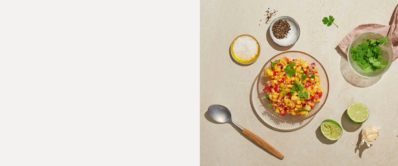 Mangosalsa med lime og koriander på høyre side og beige bakgrunn på venstre side