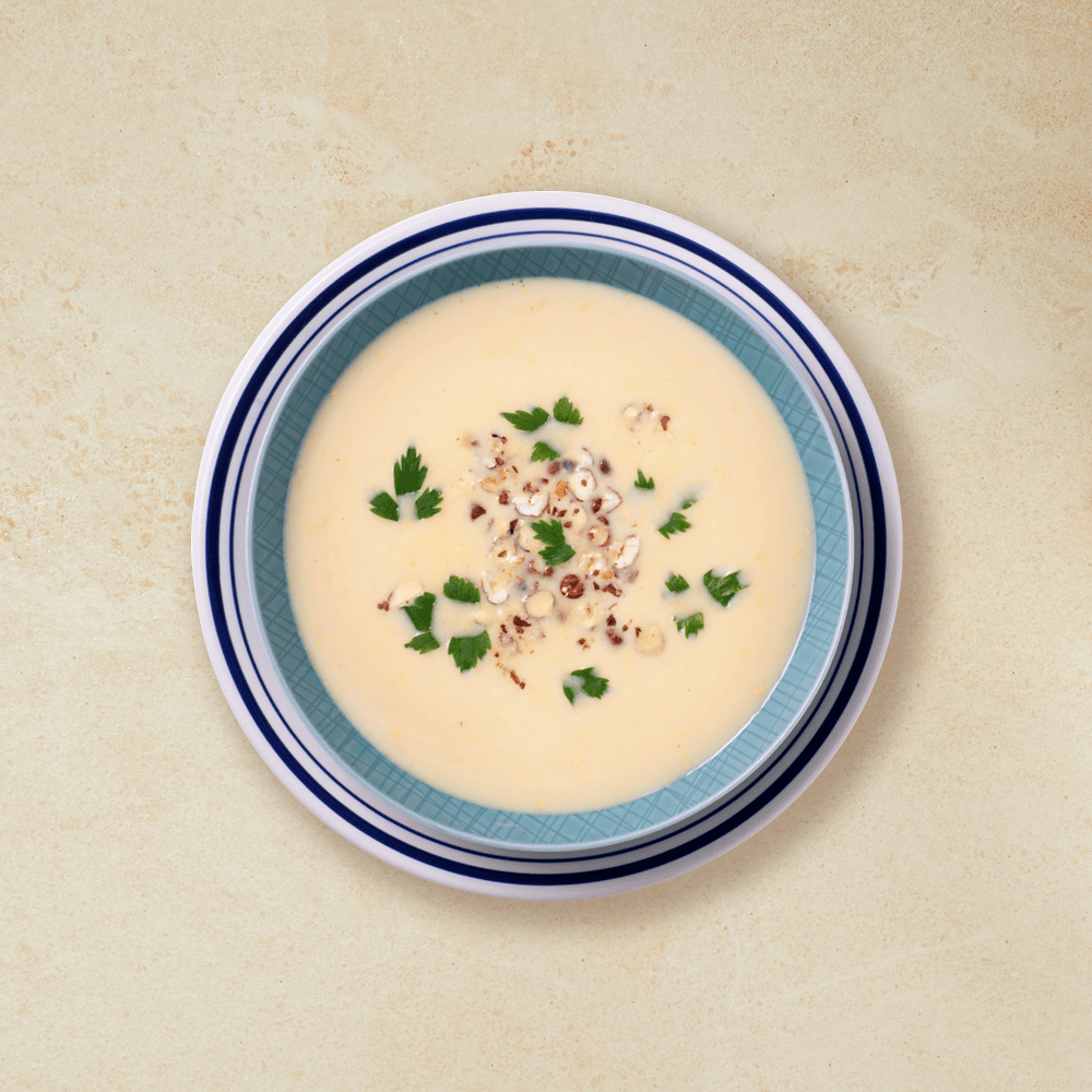 Lys søtpotetsuppe i en turkis skål.